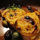 Harissa salmon fillet topped with lemon and onion rings on a plate
