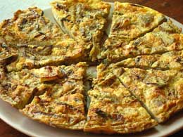 Golden fluffy omelet with roasted potatoes and zucchini served on white plate